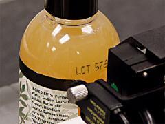 closeup of inkjet coder marking bottle shoulder